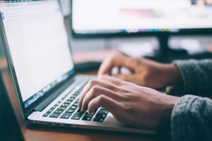 man typing on computer